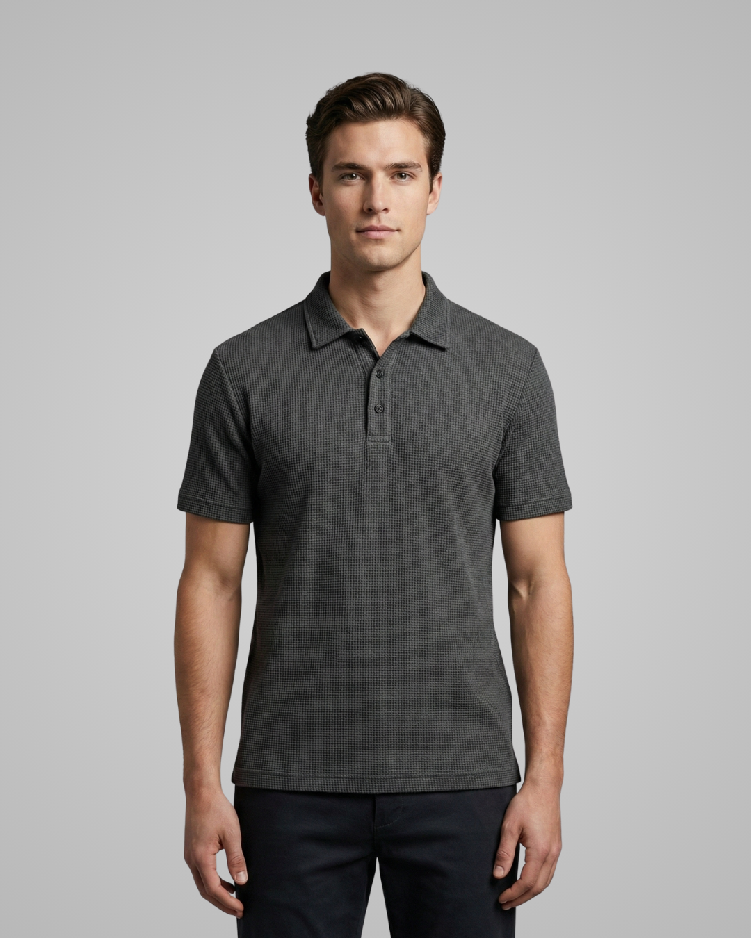 Man wearing a dark gray polo shirt against a plain background