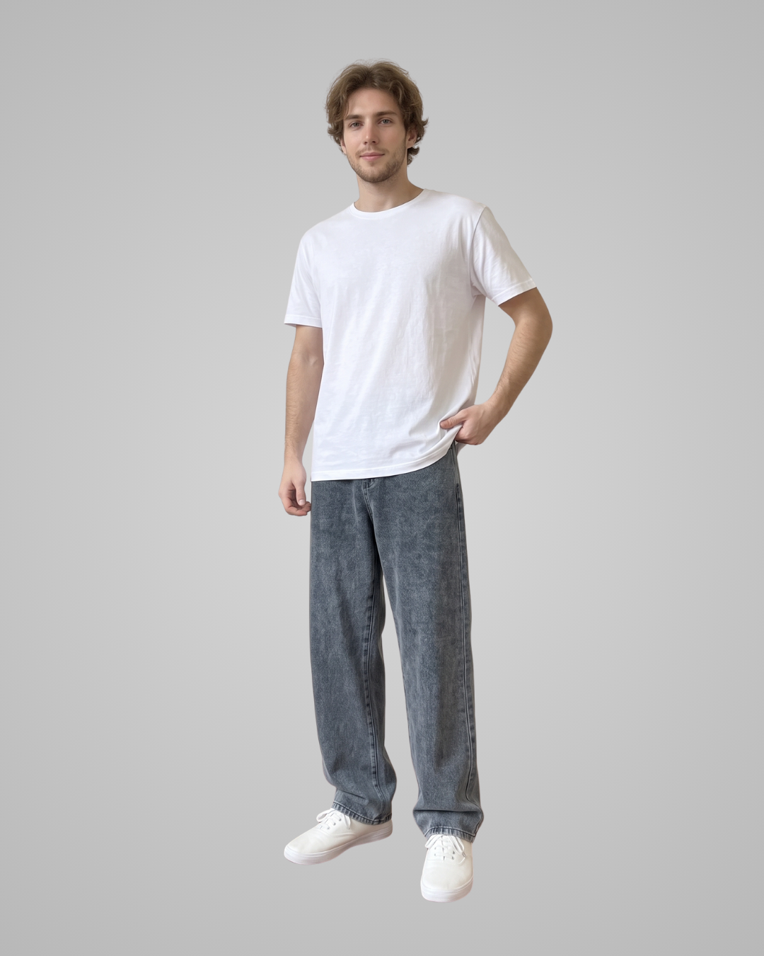 Man wearing a white t-shirt and gray jeans on a plain background