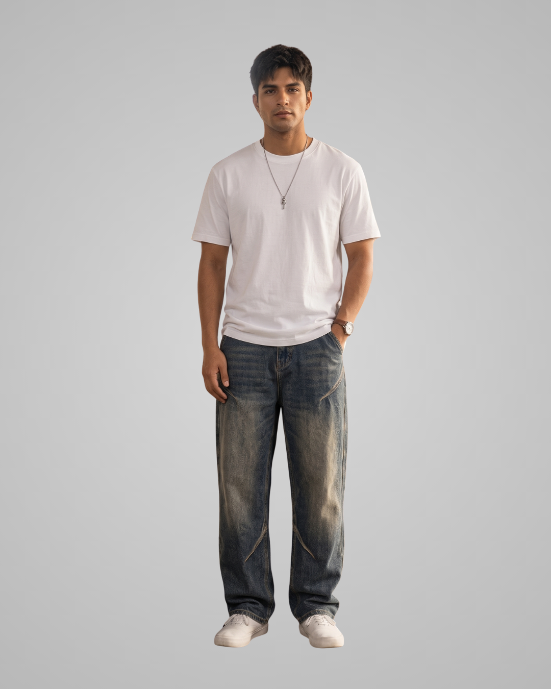 Man wearing a white t-shirt and dark jeans on a gray background