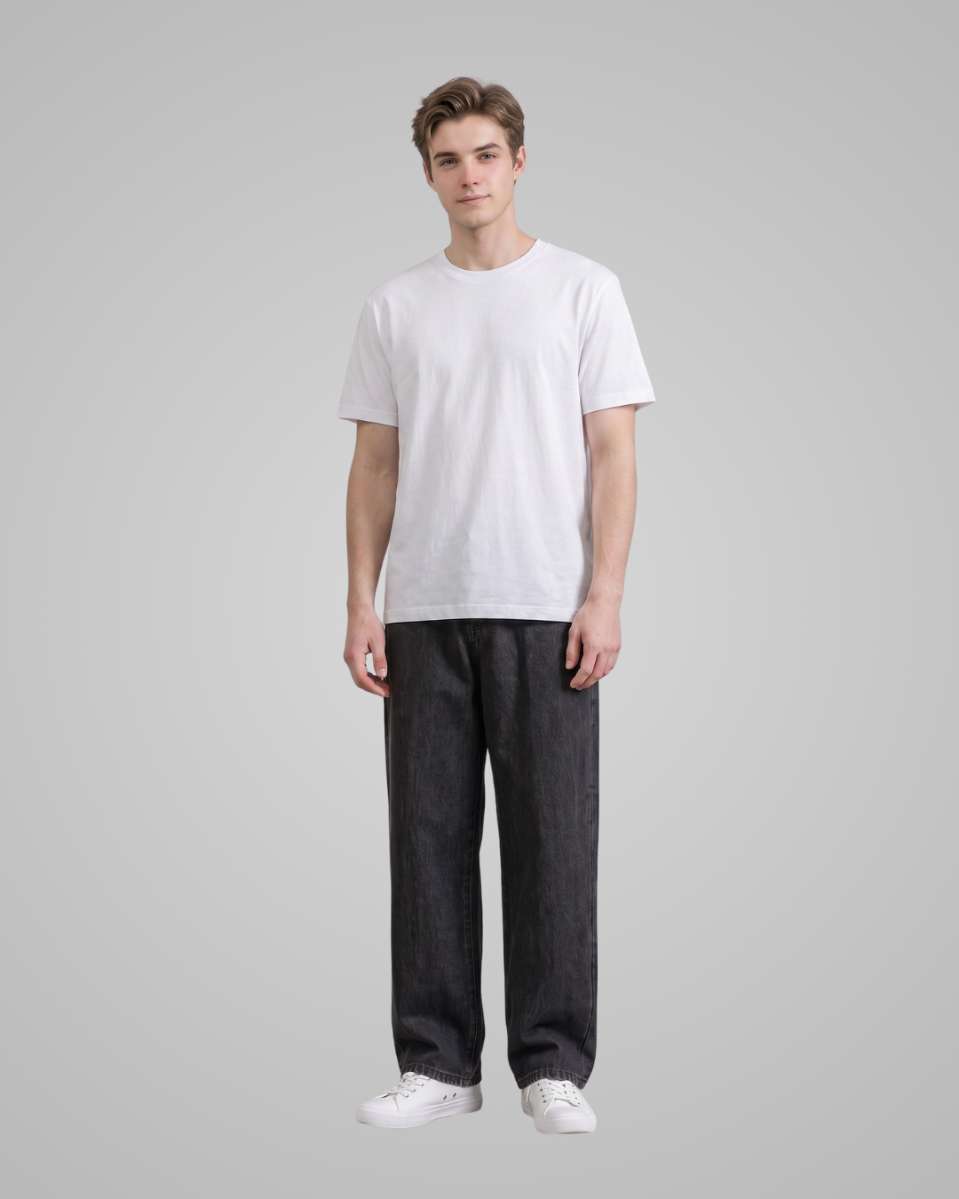 Person wearing a plain white t-shirt and dark jeans on a gray background
