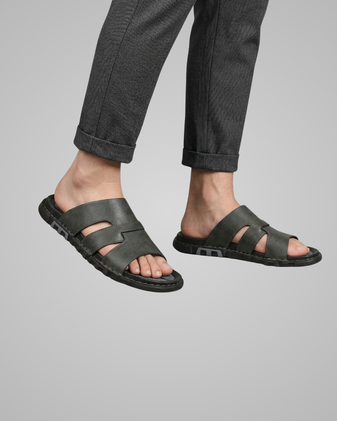 Person wearing black sandals on a gray background