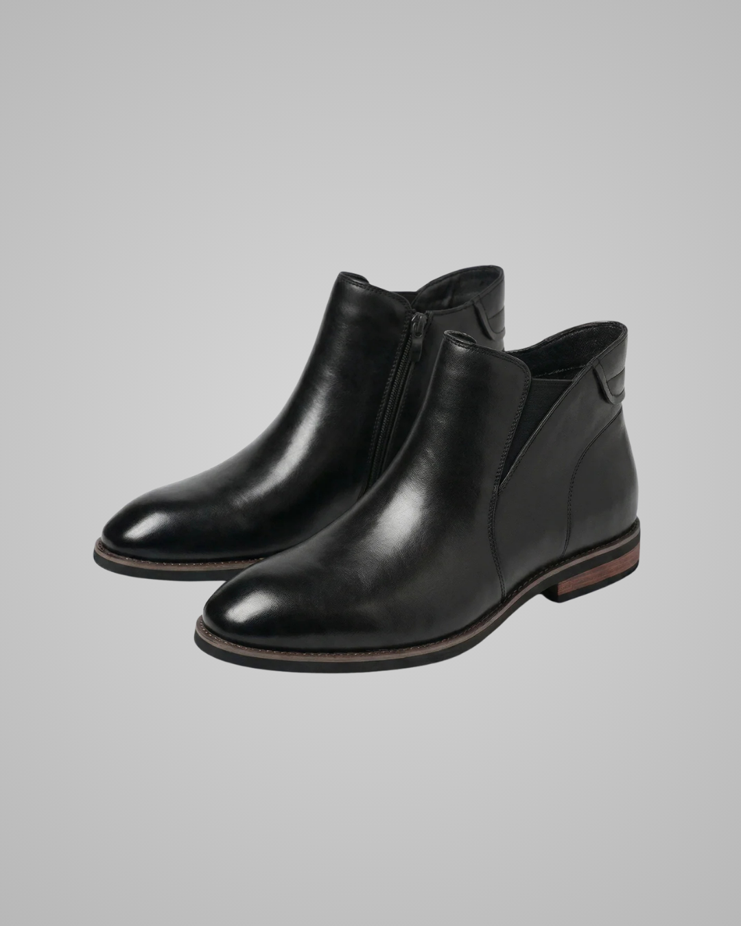 Pair of black leather ankle boots on a gray background