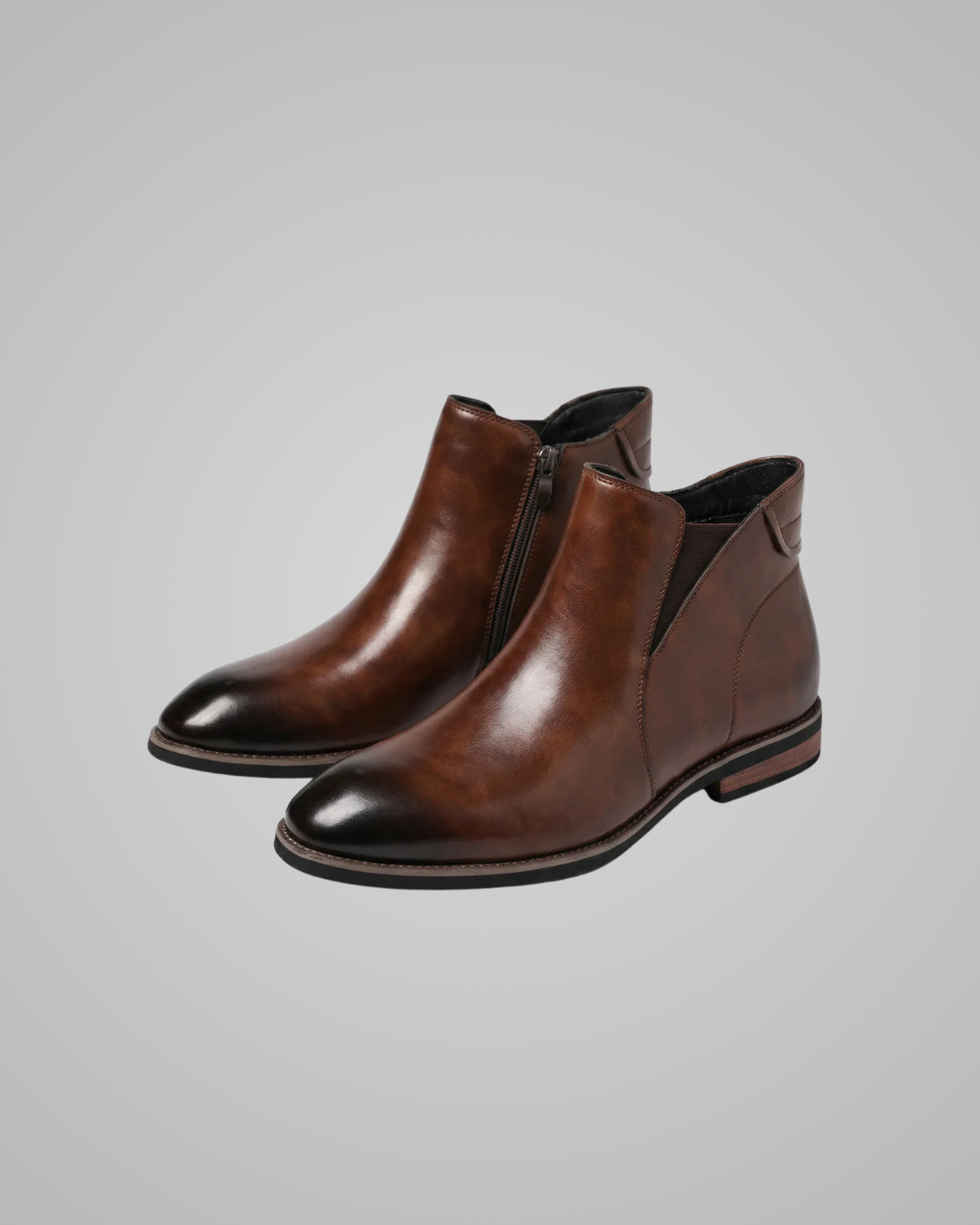 Pair of brown leather ankle boots on a gray background