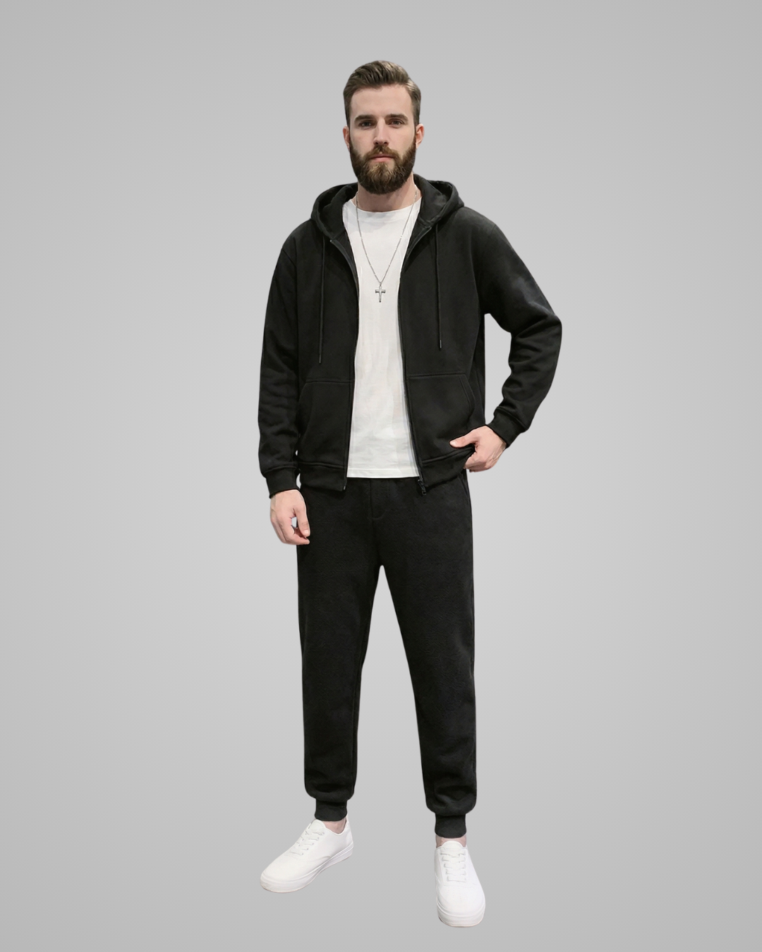 Man wearing a black hoodie and black pants on a gray background