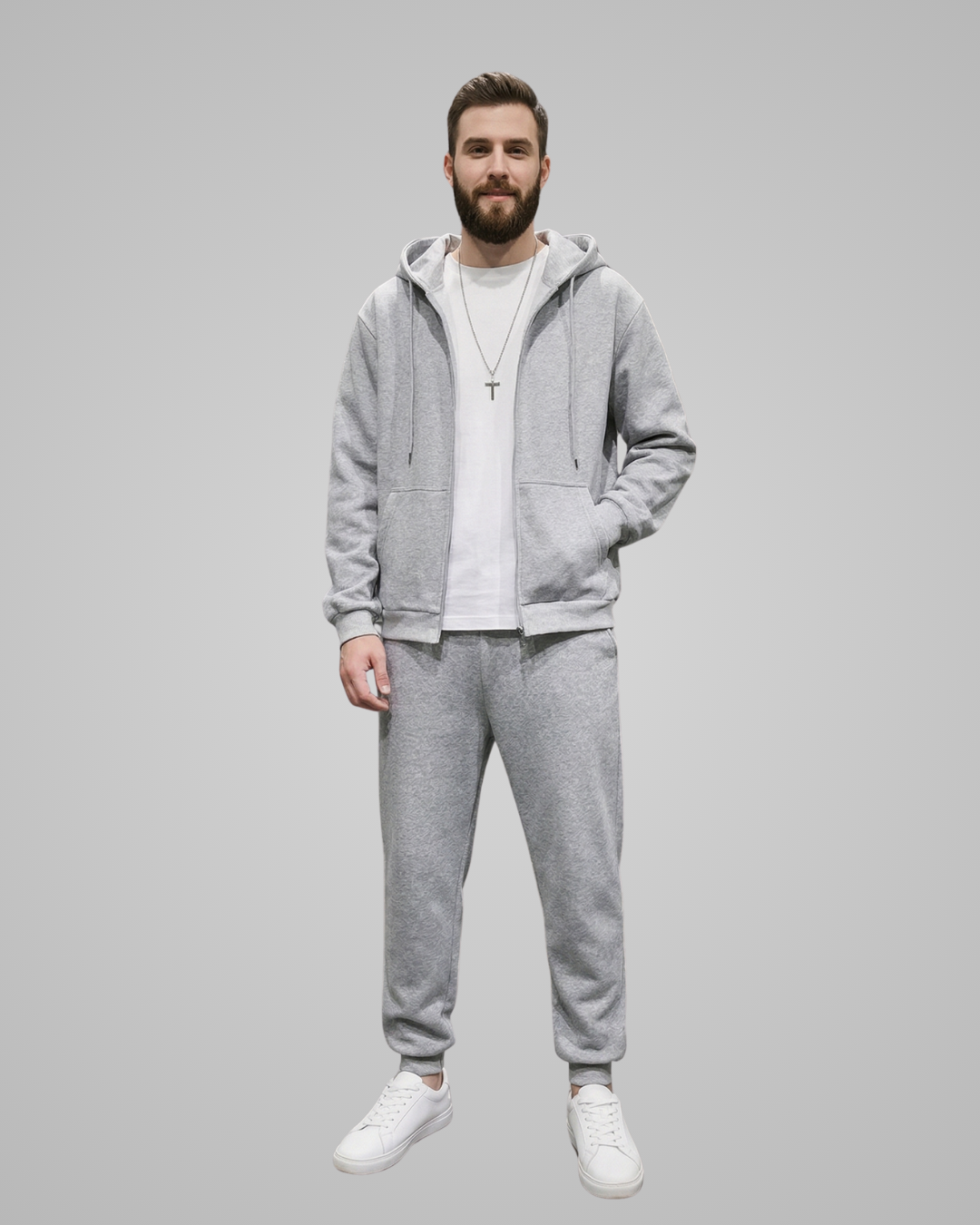 Man wearing a gray tracksuit with a plain background
