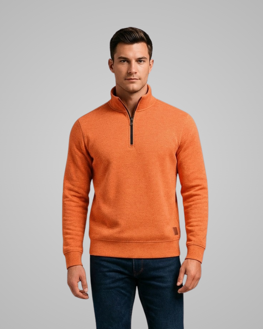 Man wearing an orange sweater against a gray background