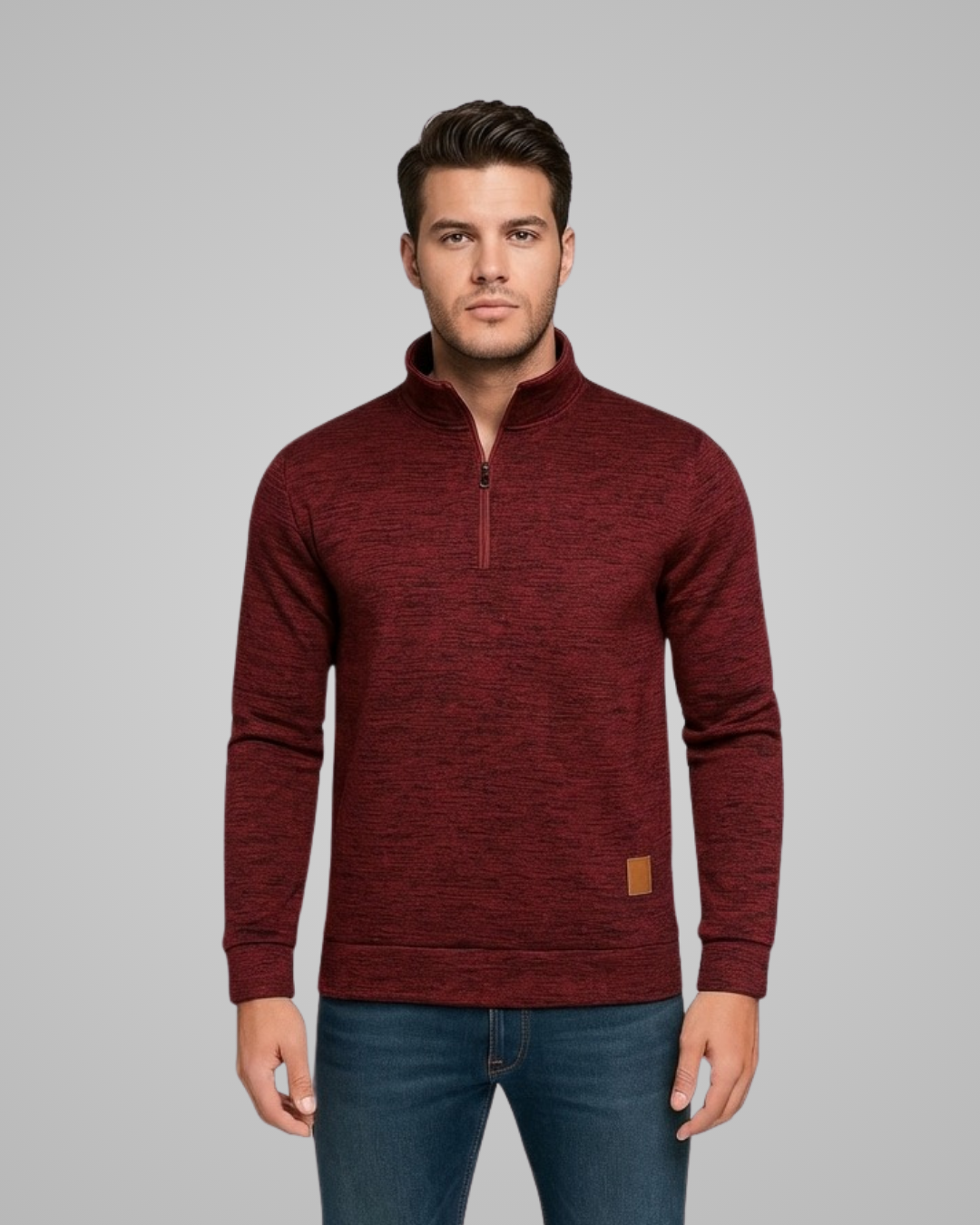 Man wearing a maroon pullover with a zipper on a gray background