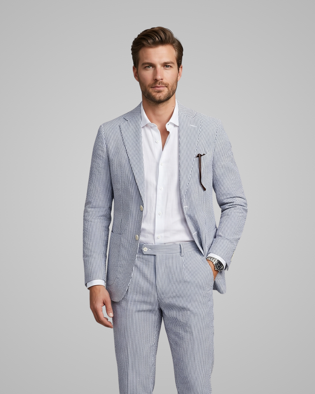 Man wearing a light gray pinstripe suit with a white shirt on a gray background