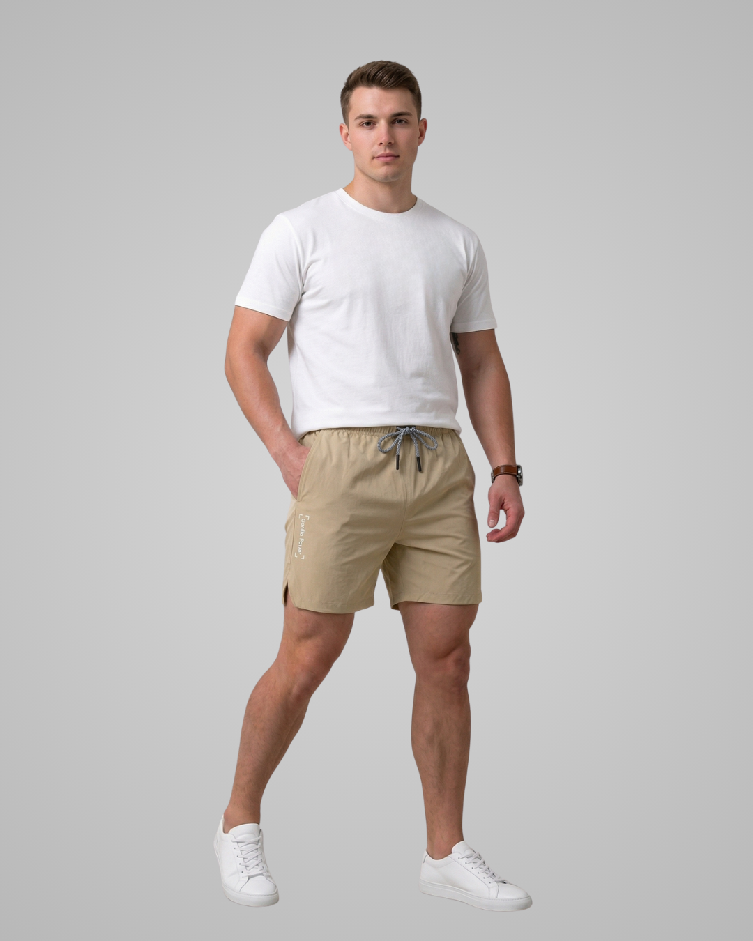 Man wearing a white t-shirt and beige shorts on a gray background