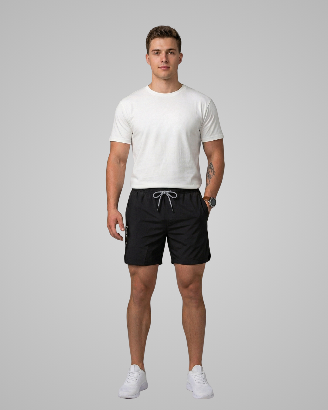 Man wearing a white t-shirt and black shorts on a gray background