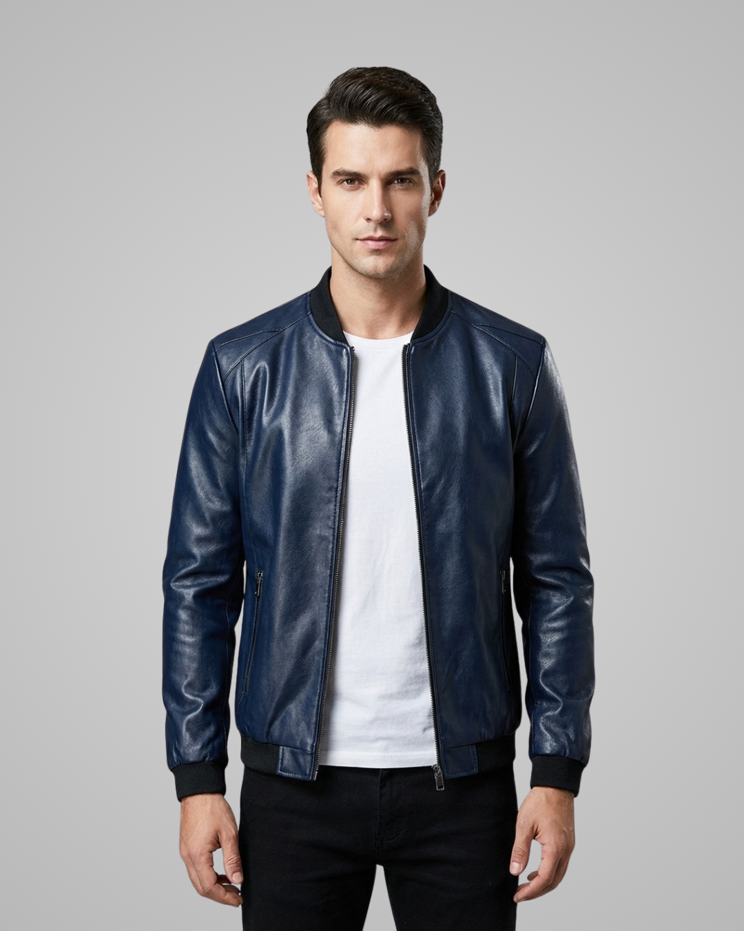Man wearing a blue leather jacket over a white shirt on a gray background