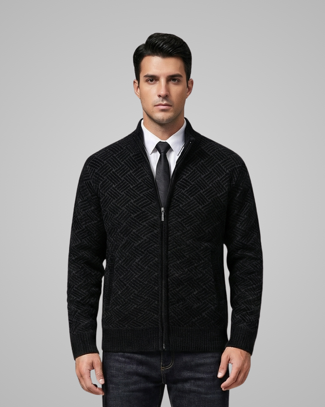 Man wearing a black patterned jacket over a white shirt with a black tie on a gray background