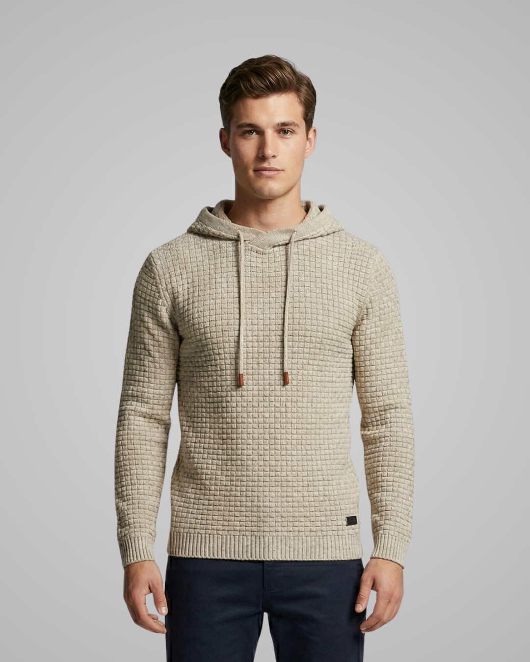 Man wearing a beige textured hoodie against a gray background