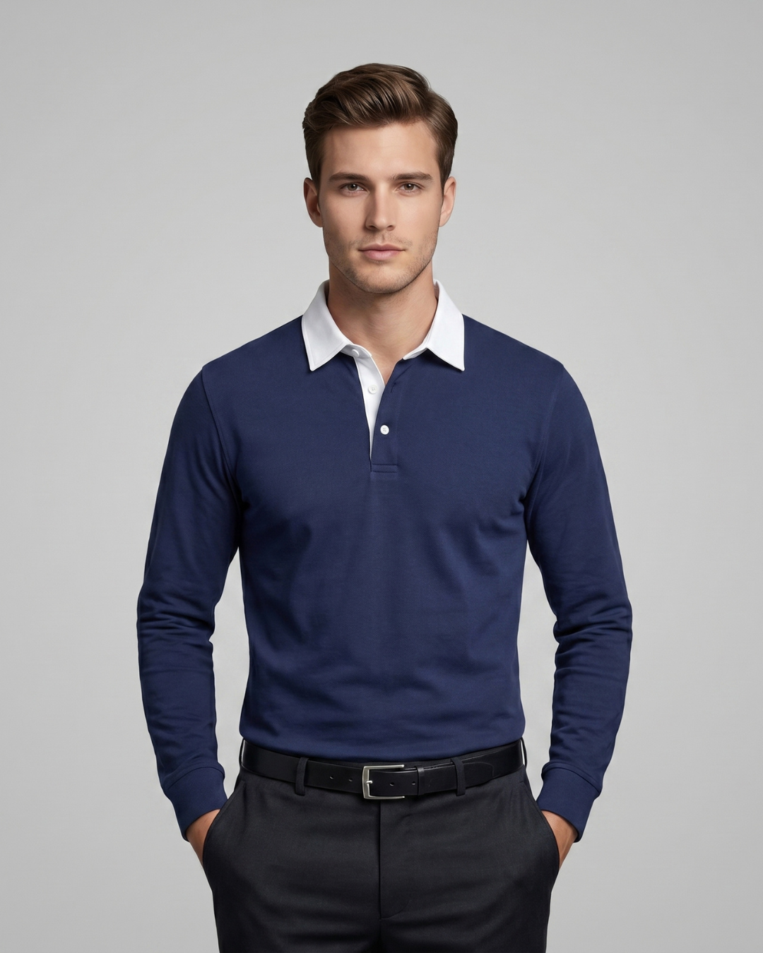 Man wearing a blue long-sleeve polo shirt with a white collar against a gray background