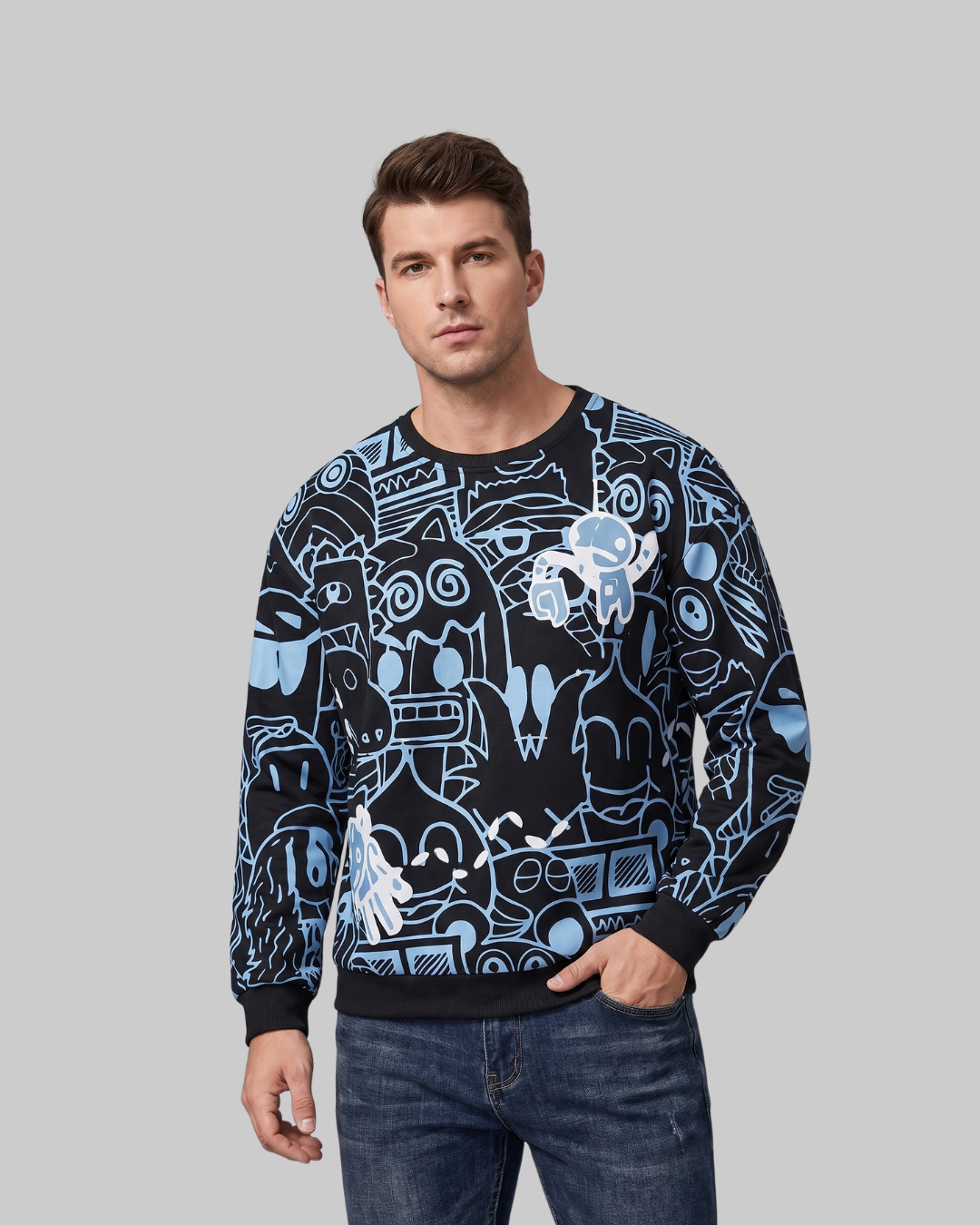 A man wearing a black crewneck sweatshirt with a light blue and white graphic pattern, paired with blue jeans, against a solid gray background.