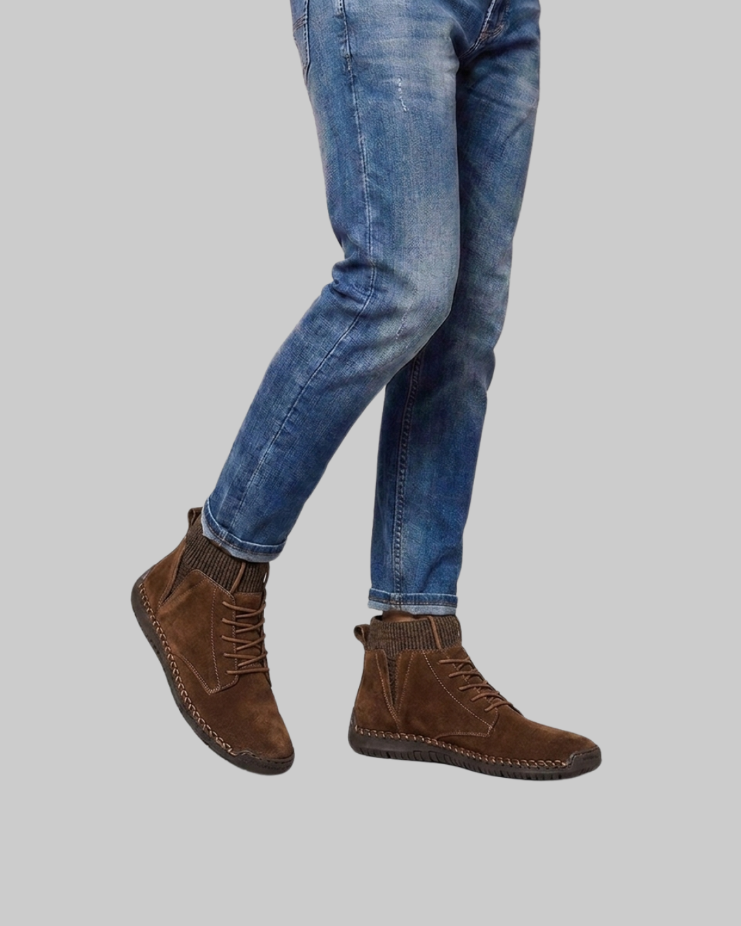 A person wearing blue jeans and black high-top platform sneakers, shown from the waist down against a plain light gray background.