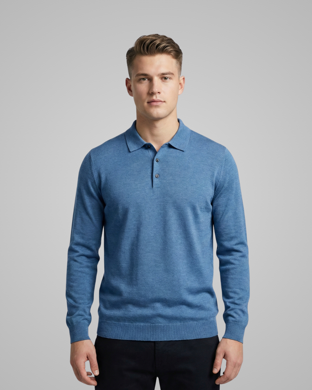 Man wearing a blue sweater over a collared shirt on a gray background