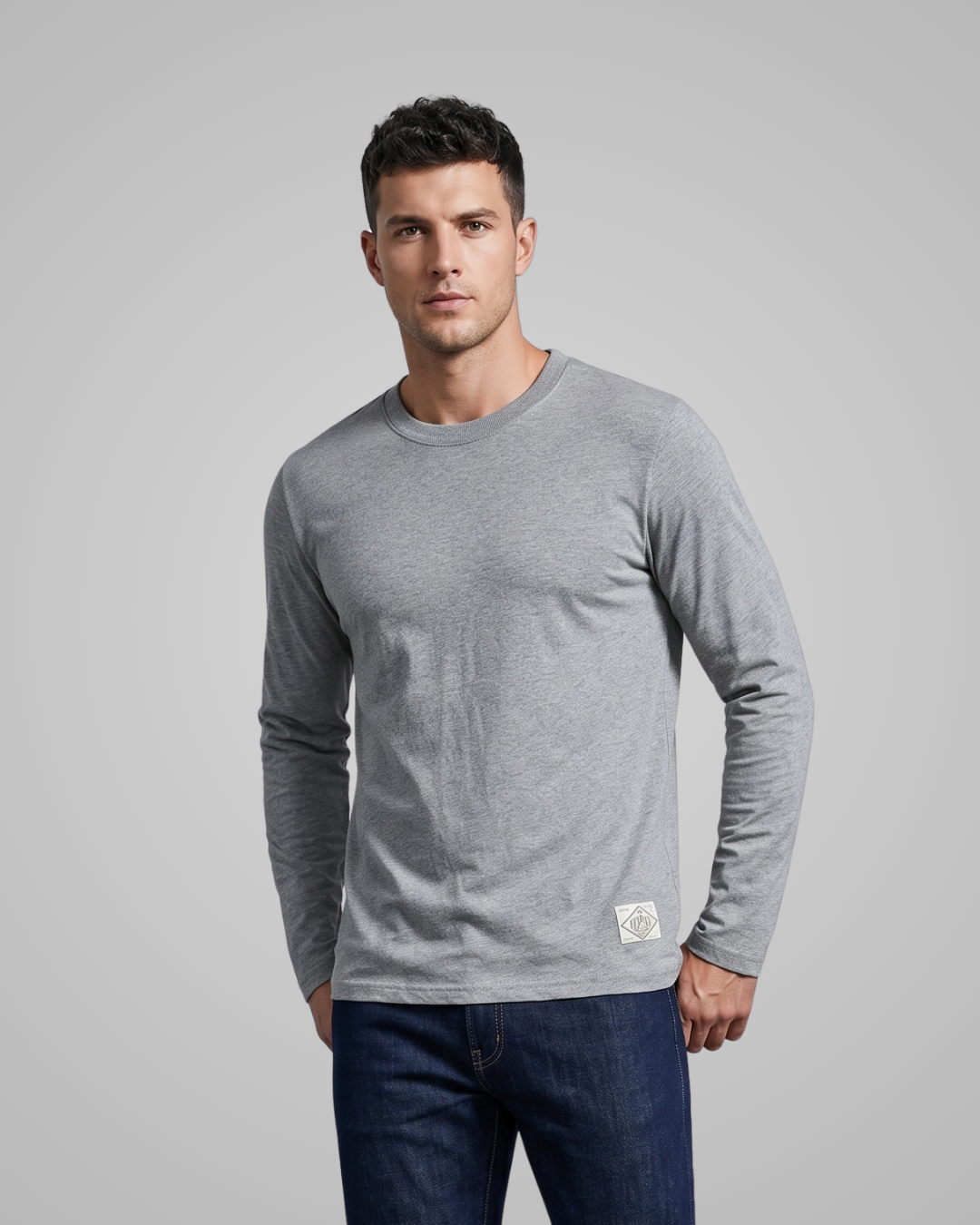 Man wearing a gray long-sleeve shirt with a logo on a gray background