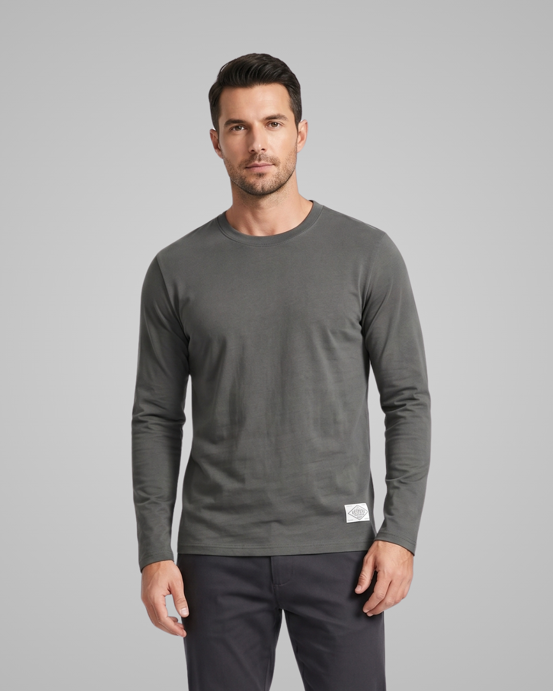 Man wearing a gray long-sleeve shirt on a gray background
