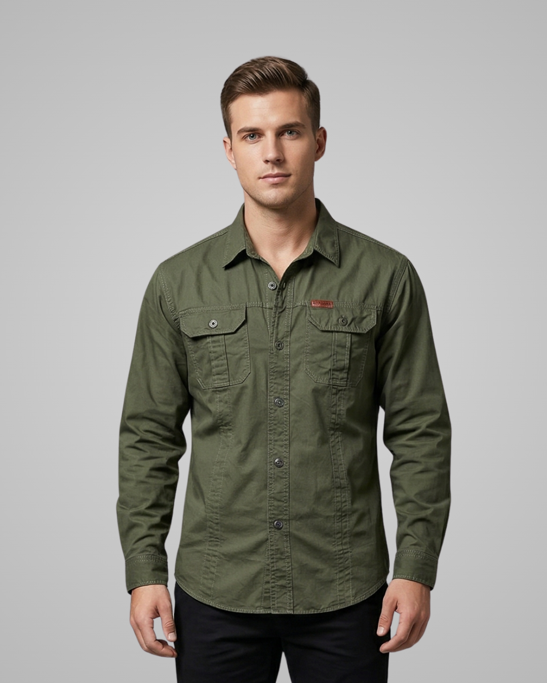 Man wearing a green shirt with a small logo on a gray background