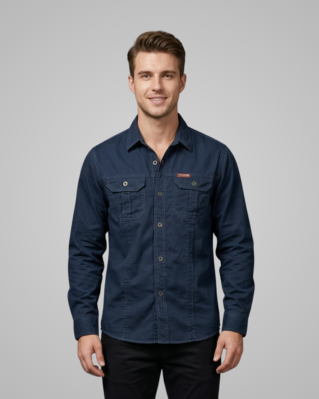 Man wearing a blue shirt with a logo on a gray background