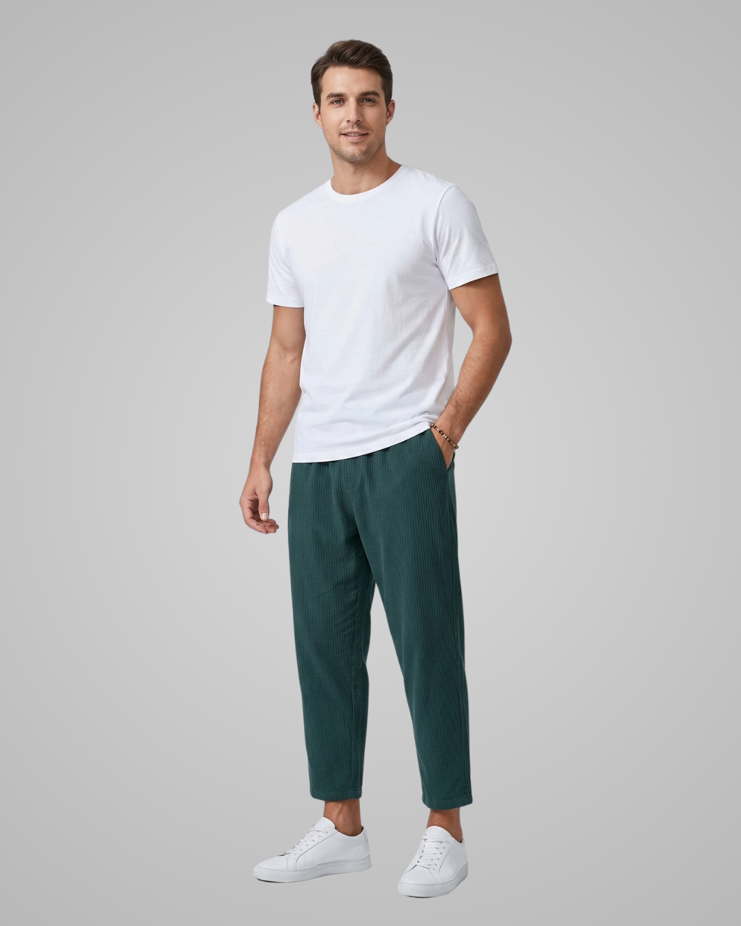 Man wearing a white t-shirt and green pants on a gray background
