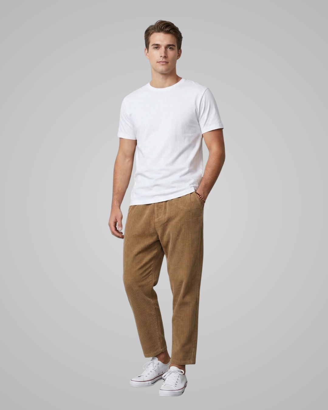 Man wearing a white t-shirt and brown pants on a gray background