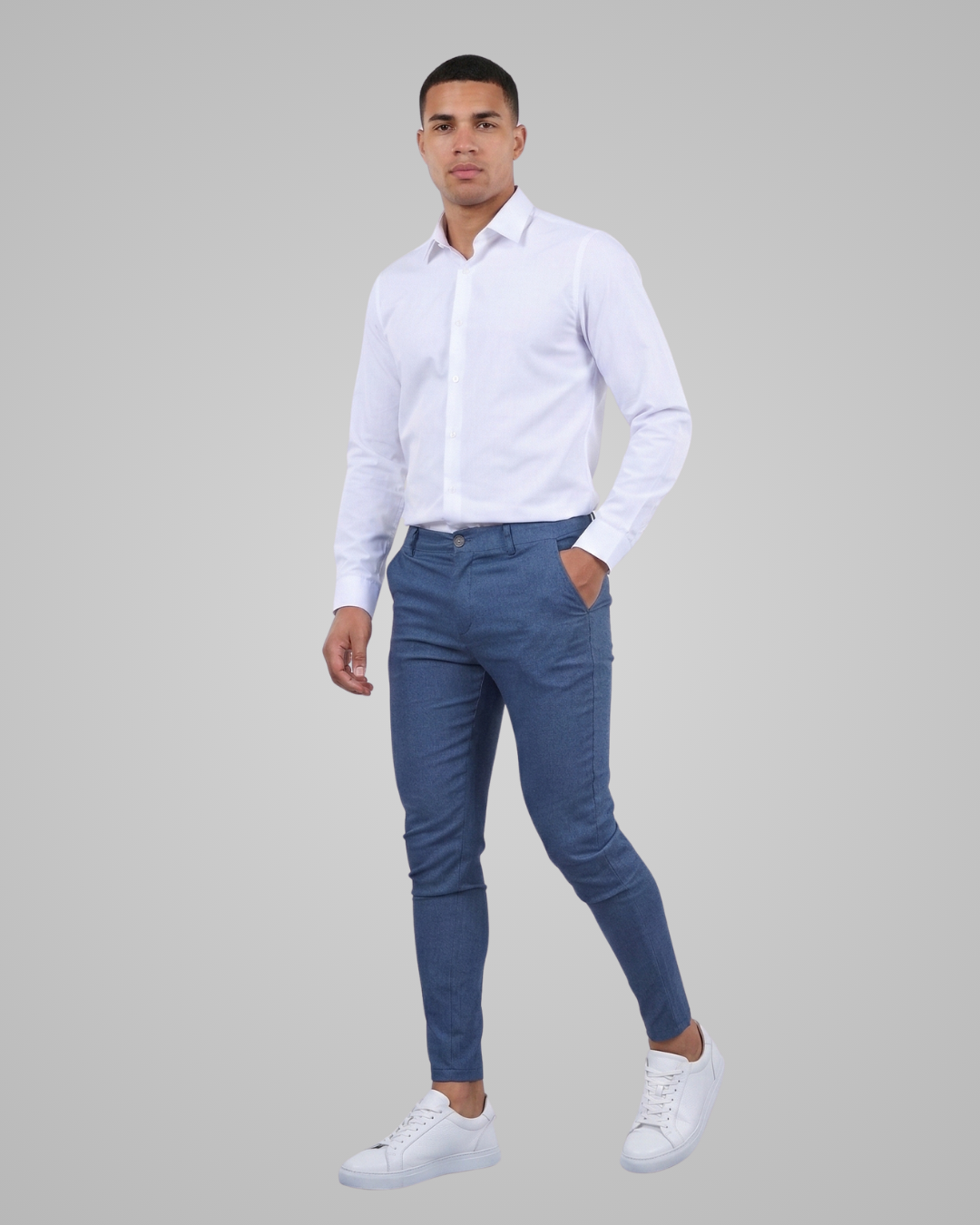 Man wearing a white shirt and blue pants on a gray background