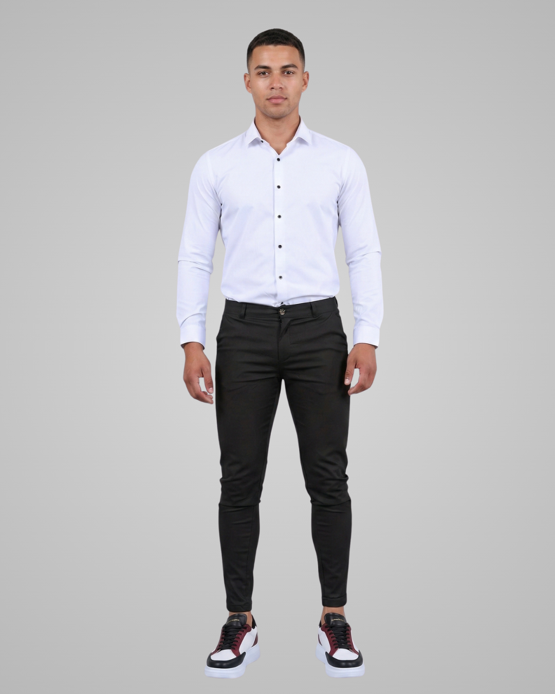 Man wearing a white dress shirt and black pants on a gray background