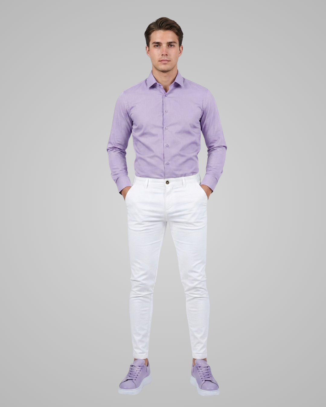 Man wearing a light purple shirt and white pants on a gray background