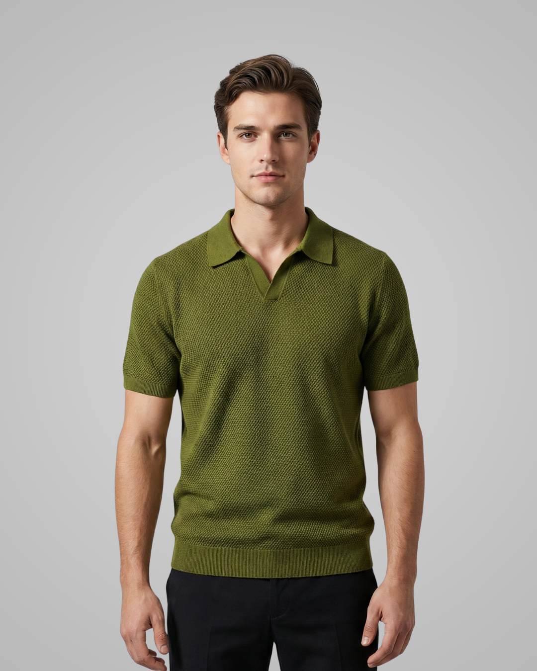 Man wearing a green patterned polo shirt against a gray background