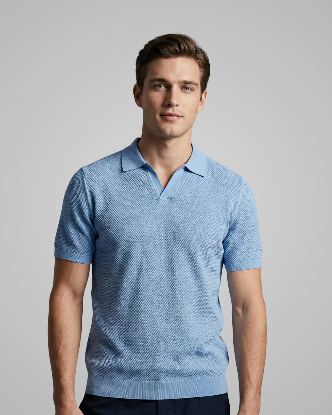 Man wearing a light blue patterned polo shirt against a gray background
