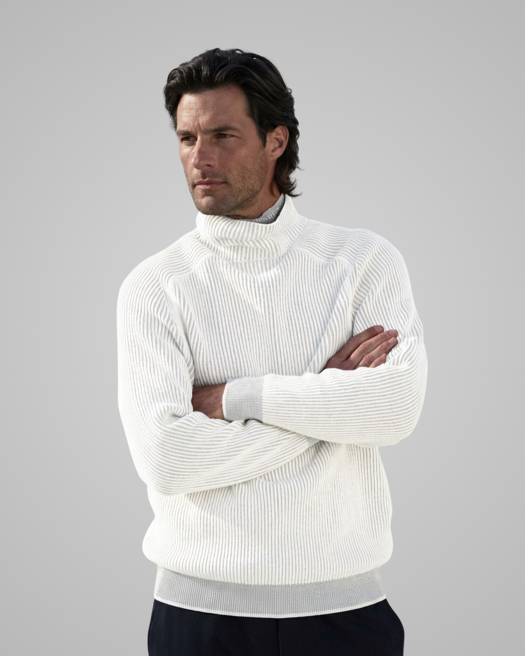 Man wearing a white turtleneck sweater against a gray background