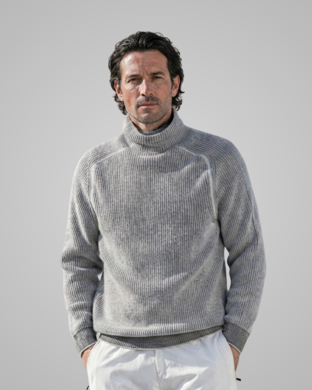 Man wearing a gray turtleneck sweater against a plain background