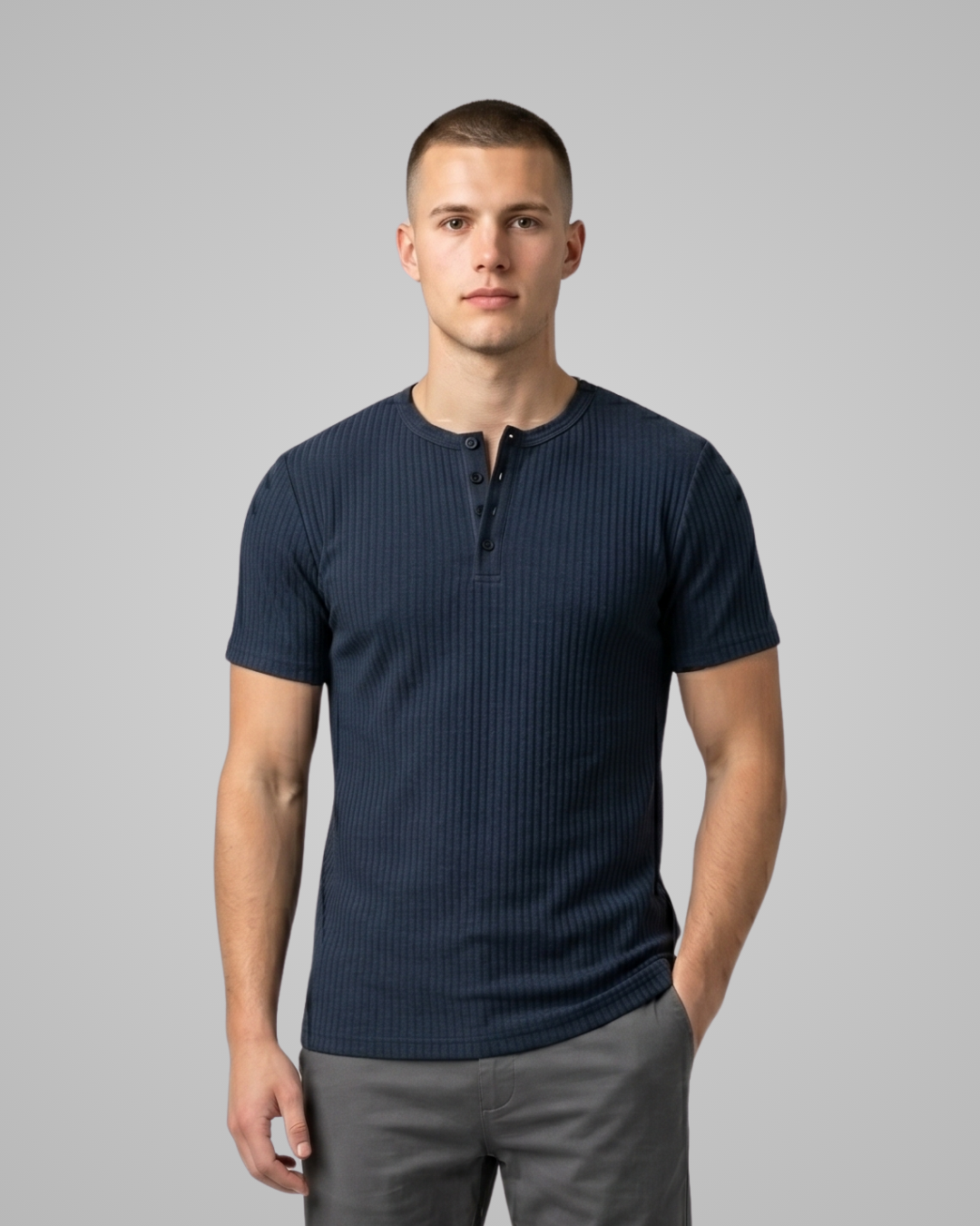 Man wearing a navy blue ribbed henley shirt against a gray background