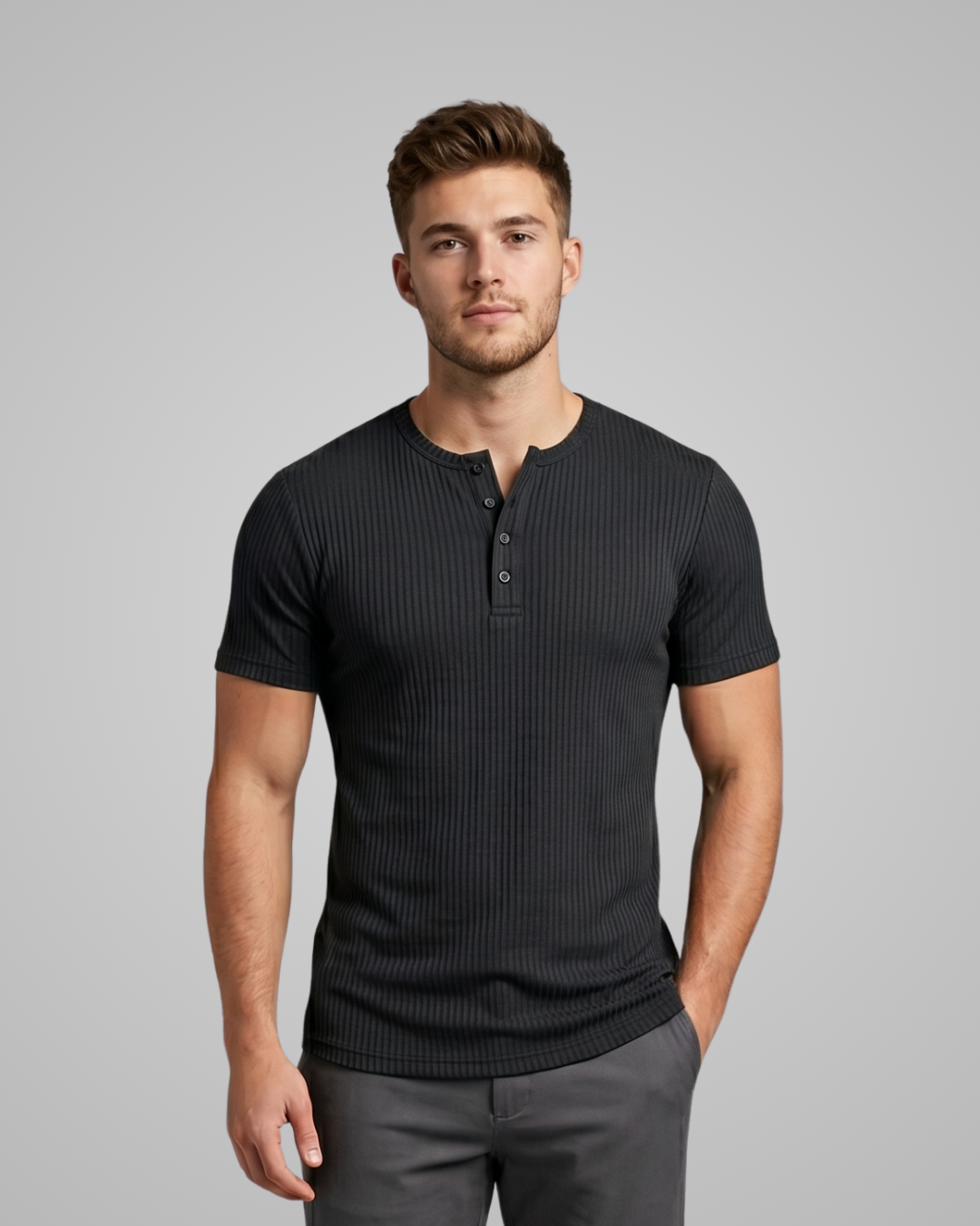 Man wearing a black ribbed henley shirt against a gray background