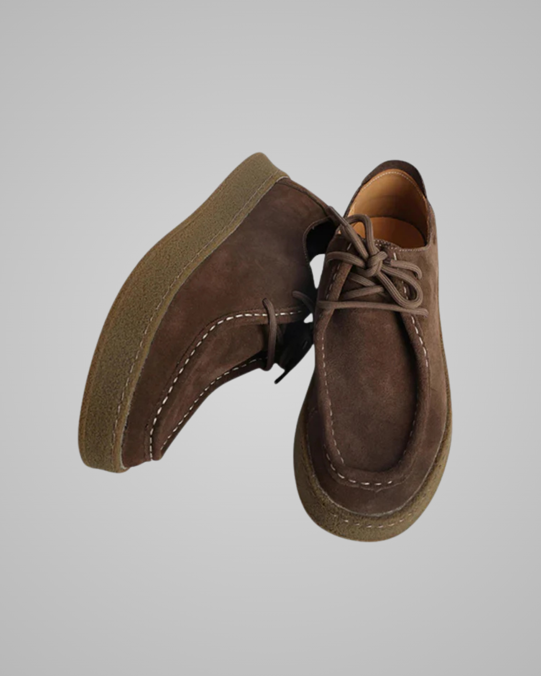 Pair of brown suede shoes on a light gray background