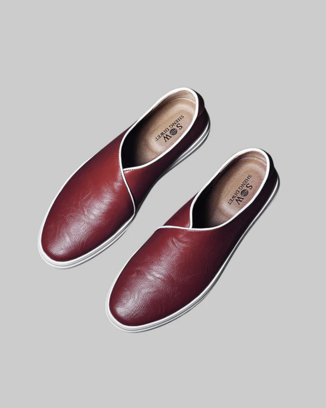 Pair of maroon leather shoes on a gray background