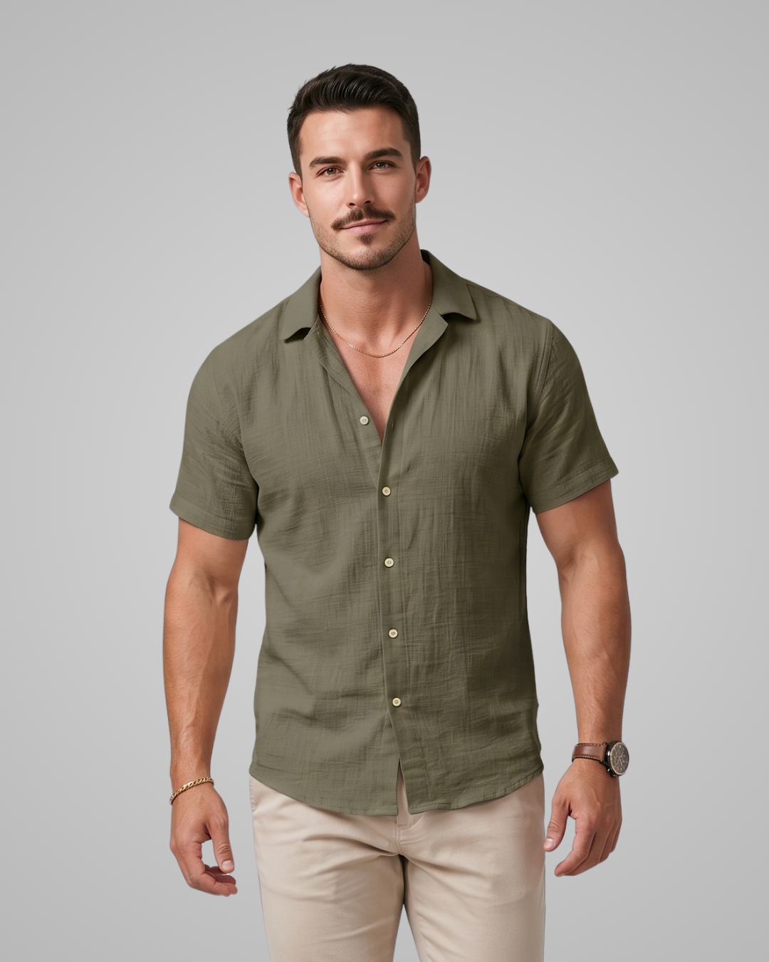 Man wearing a green short-sleeve shirt and beige pants against a gray background