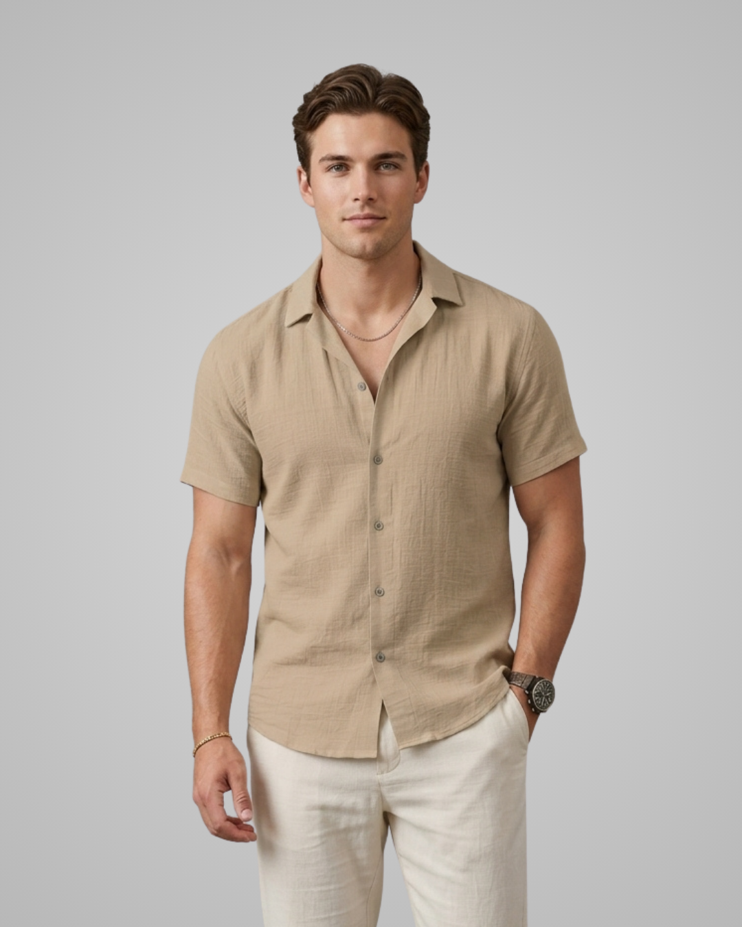 Man wearing a beige short-sleeve shirt and light-colored pants against a plain background