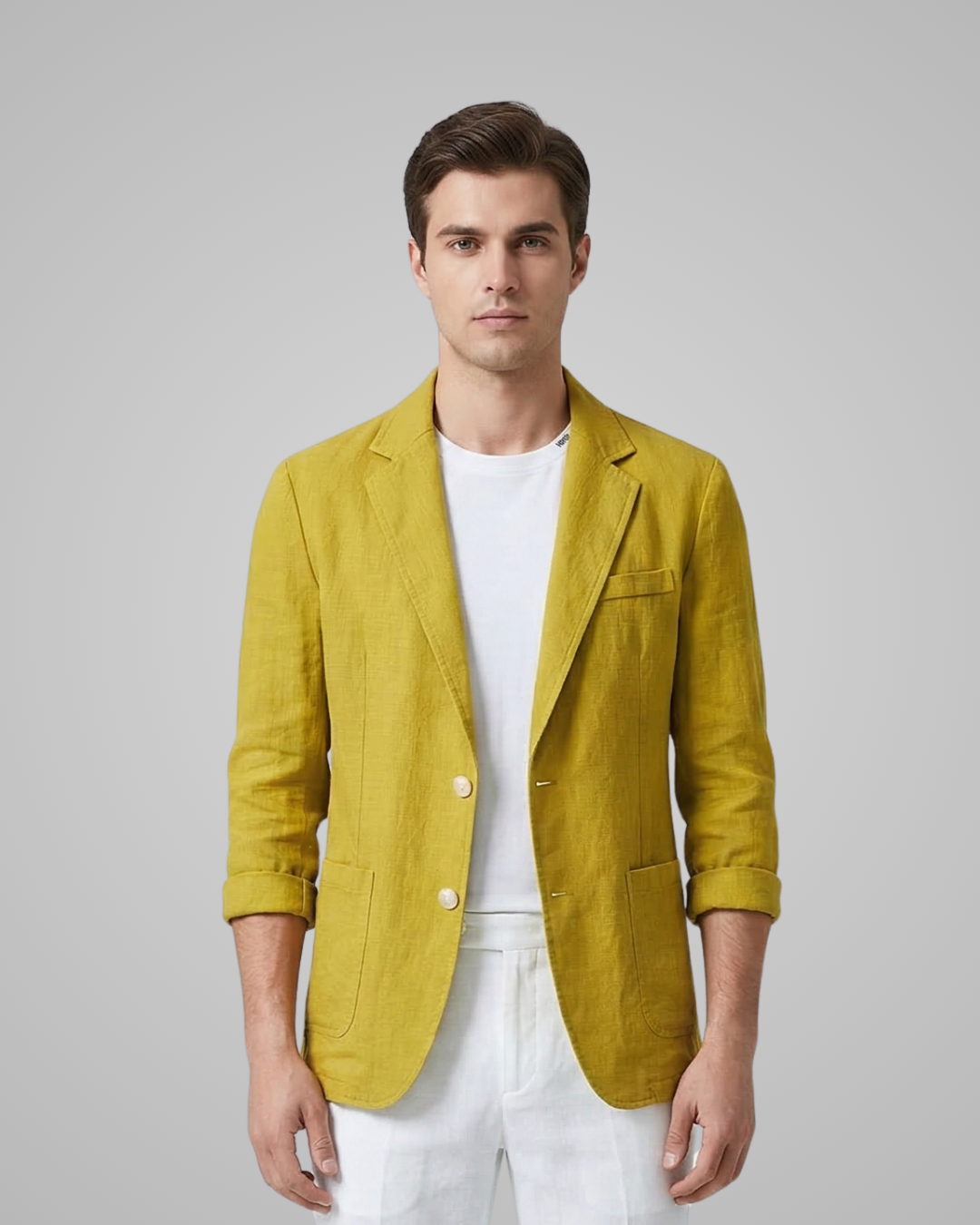 Man wearing a mustard yellow blazer over a white shirt on a gray background