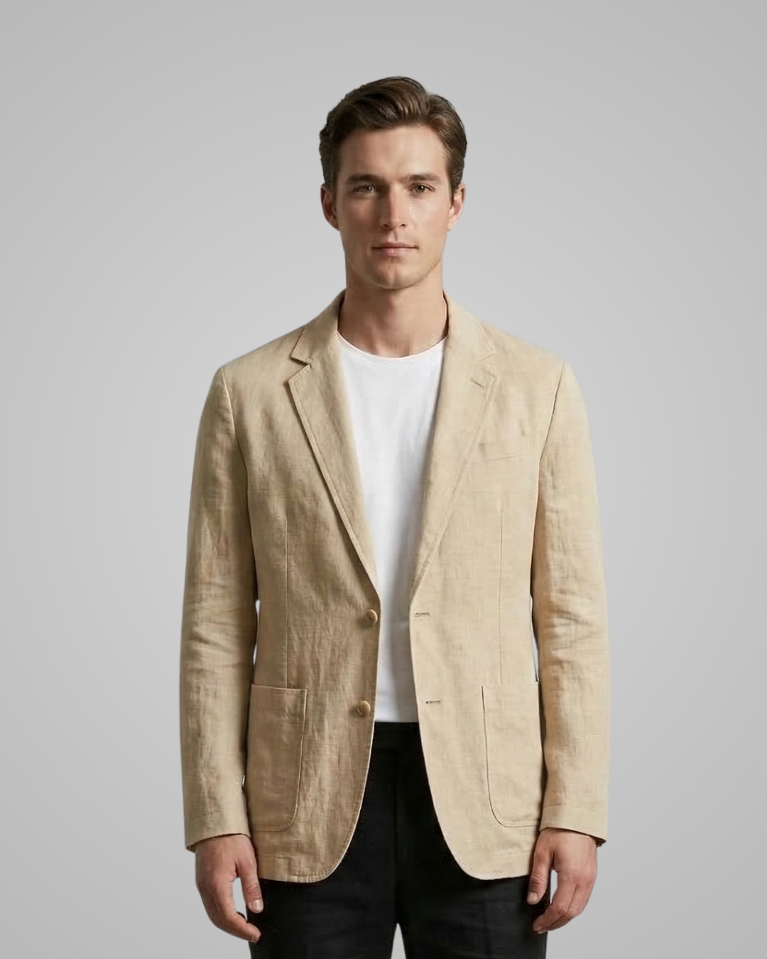 Man wearing a beige blazer over a white shirt on a gray background