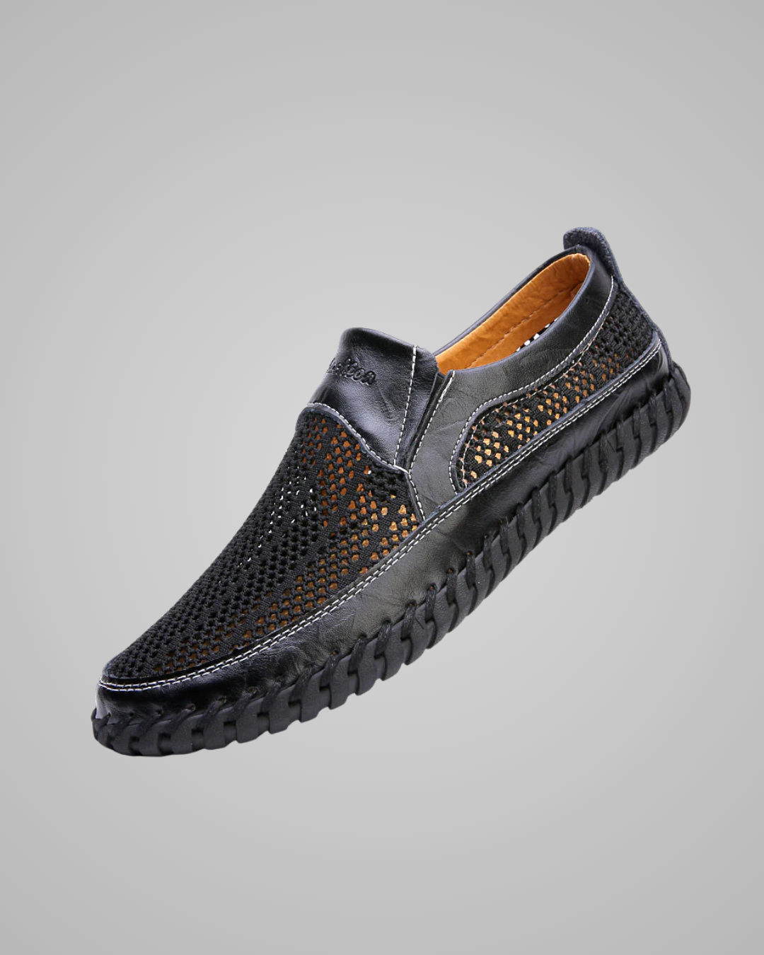 Black leather shoe with a textured sole on a gray background