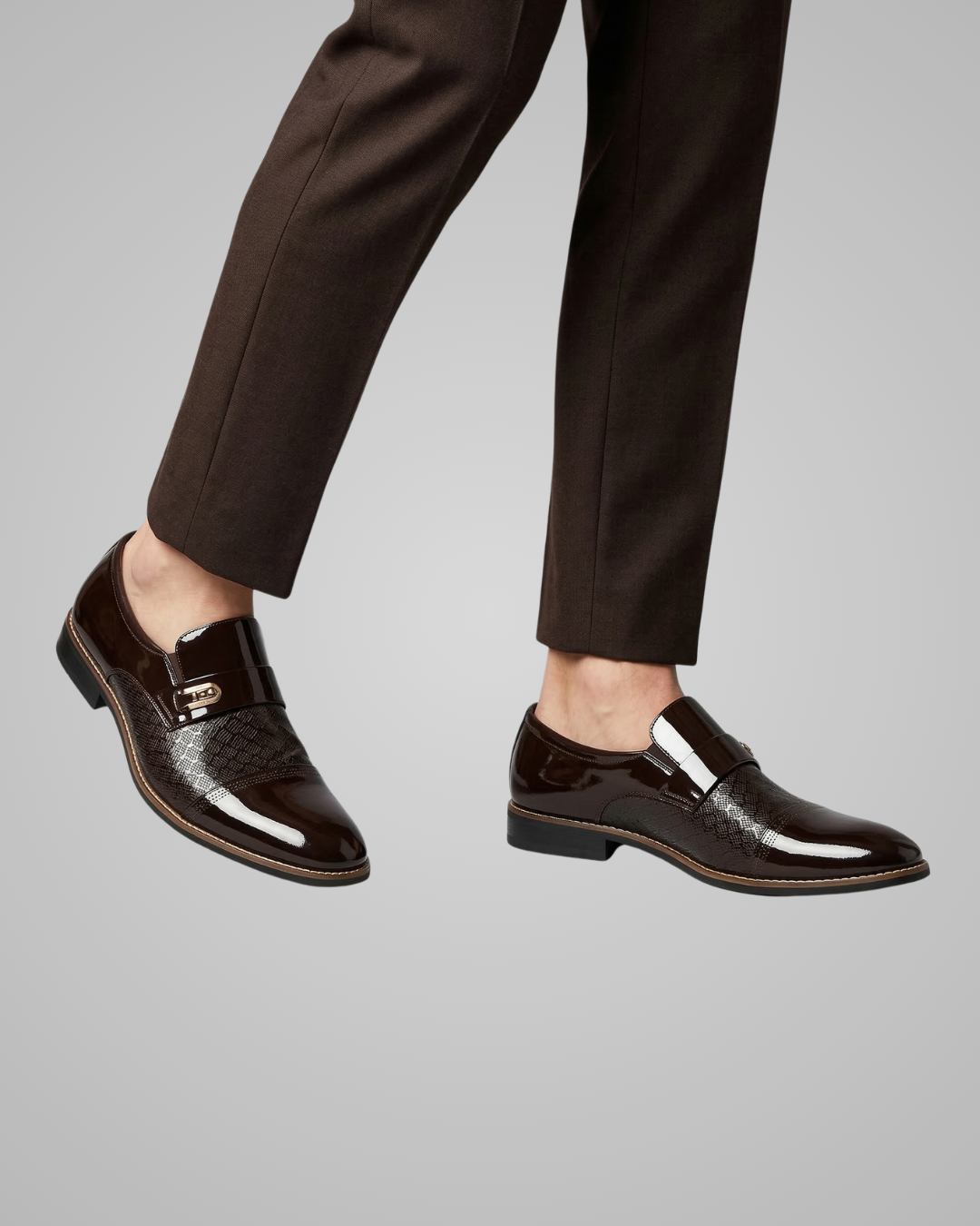 Brown dress shoes worn with black pants on a gray background