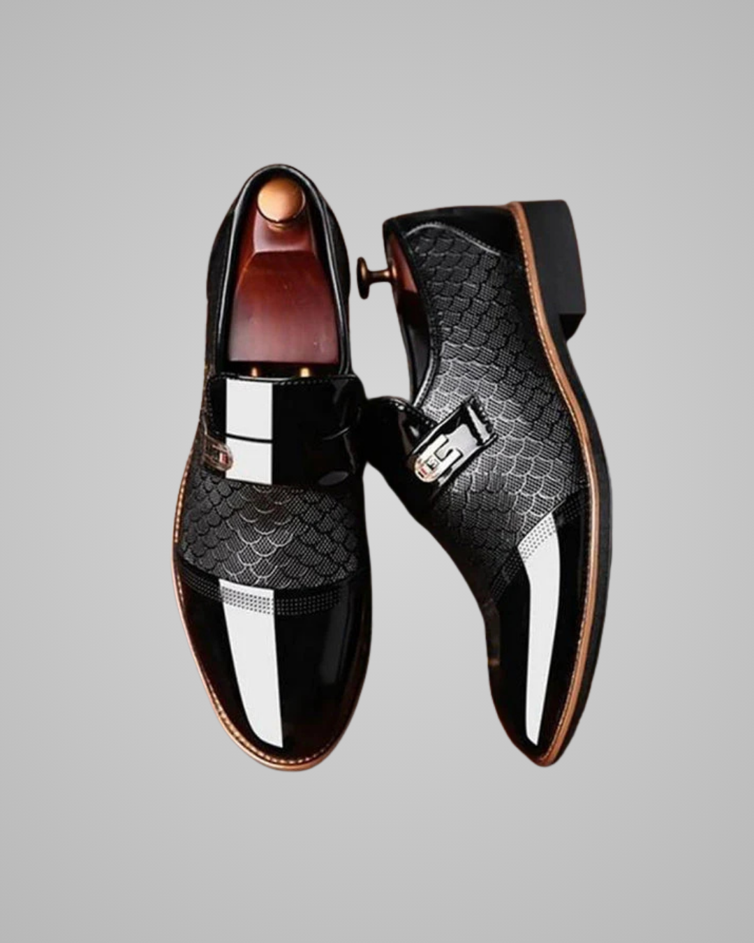 Pair of black dress shoes with metallic accents on a gray background