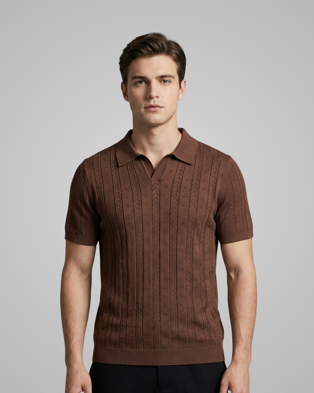 Man wearing a brown knitted polo shirt against a gray background
