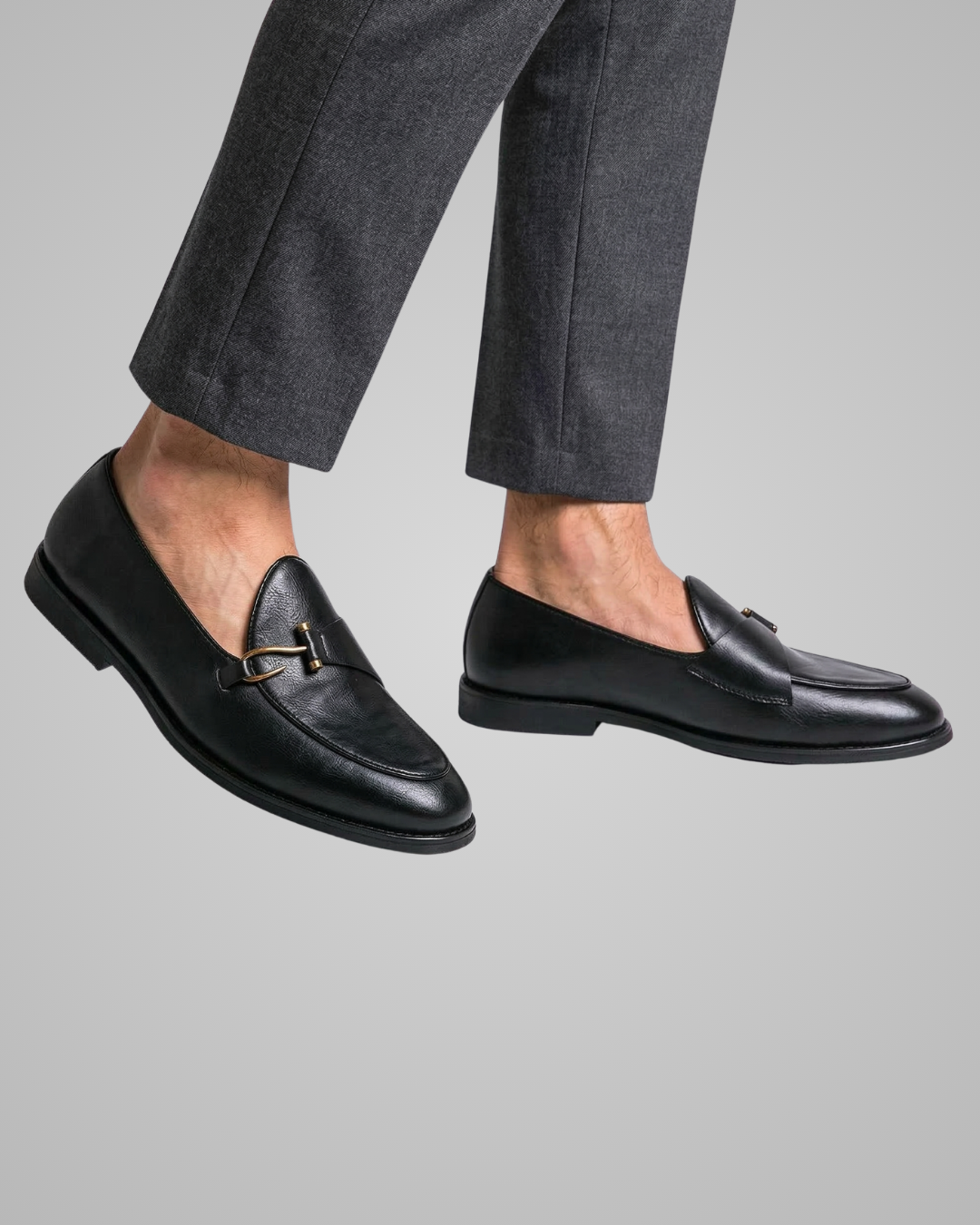 Black loafers worn with gray pants on a light gray background