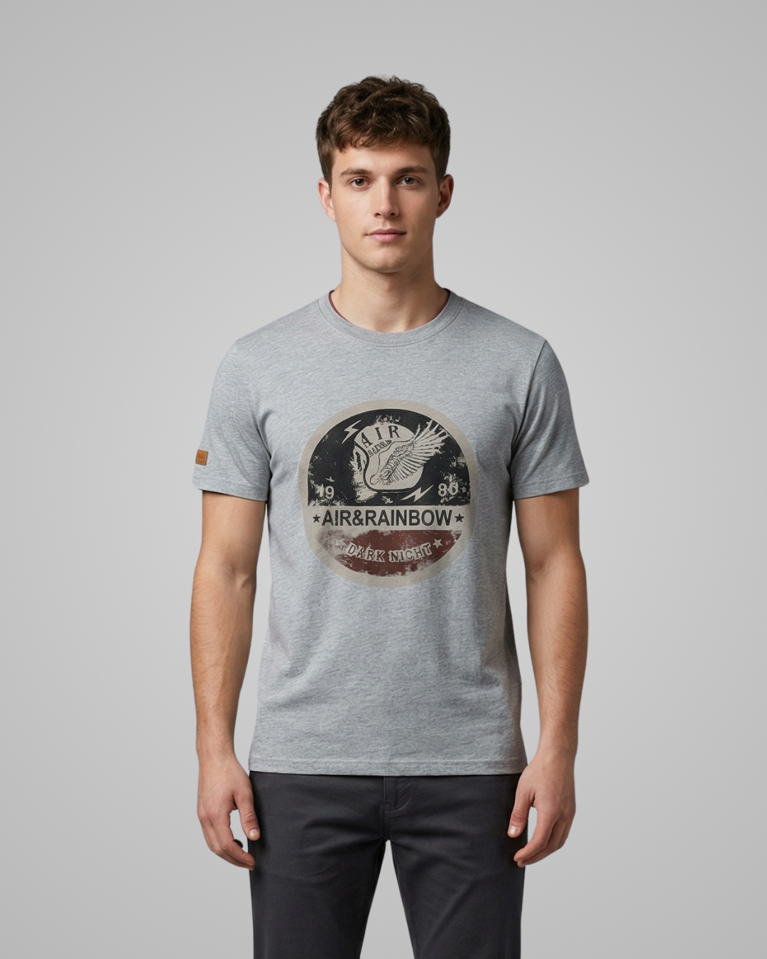 Man wearing a grey t-shirt with a logo on a gray background