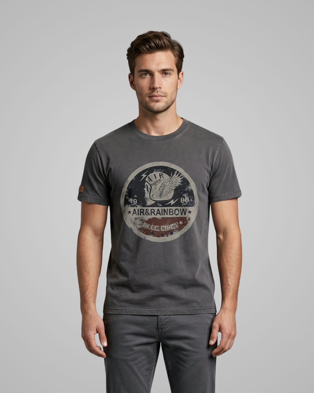 Man wearing a gray t-shirt with a logo on a gray background