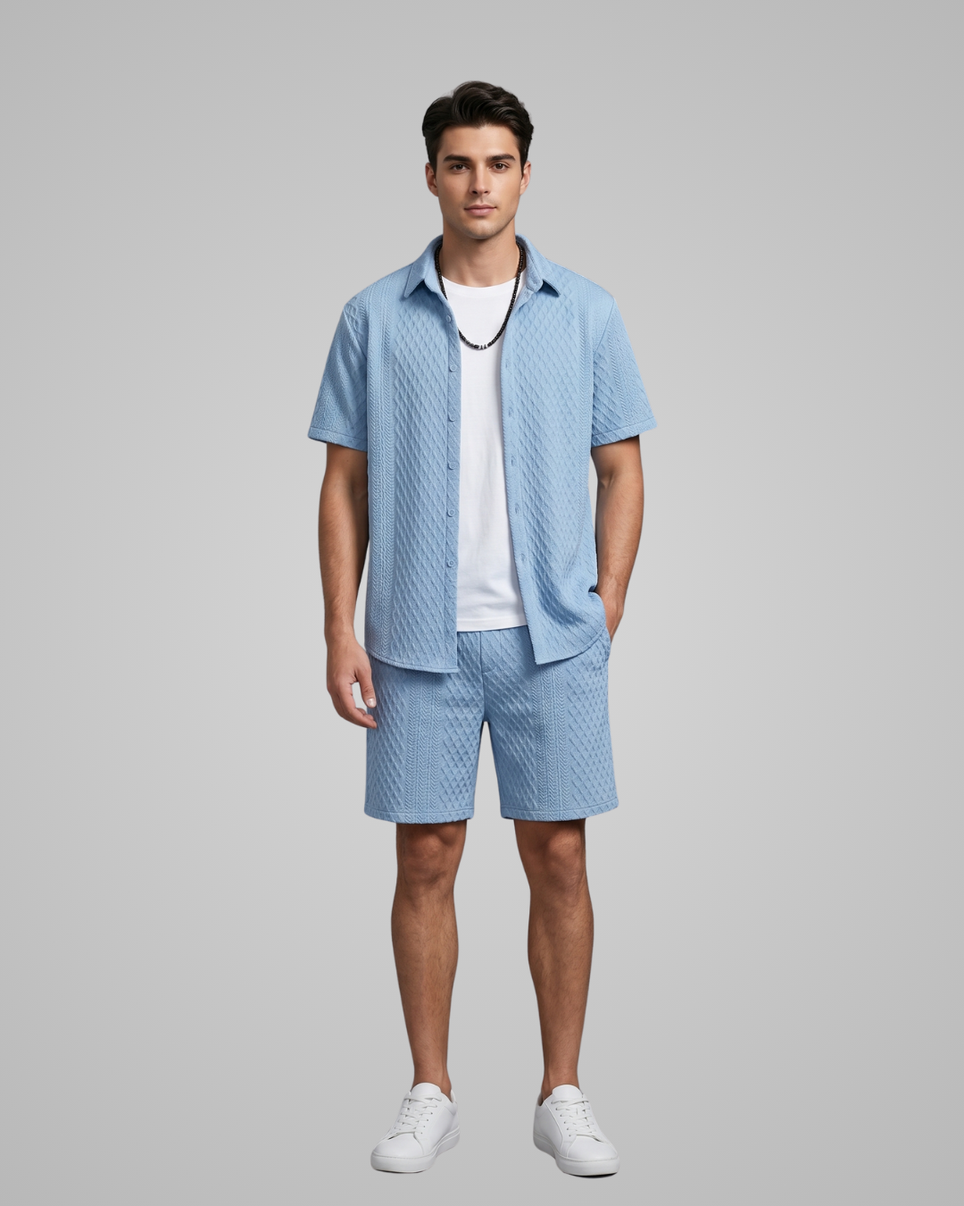 Man wearing a light blue patterned shirt and shorts set on a gray background